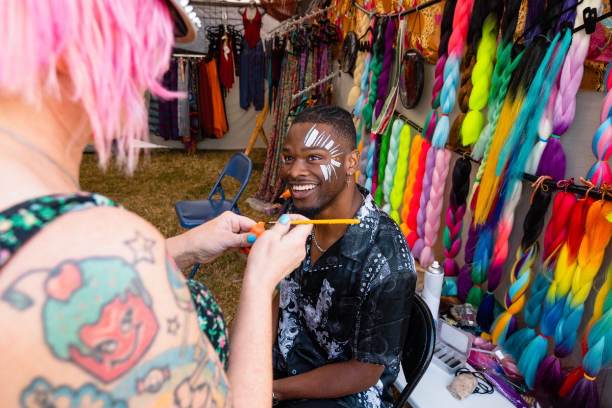 Cheerful face painted by face painter at a face painting stall in fun fair